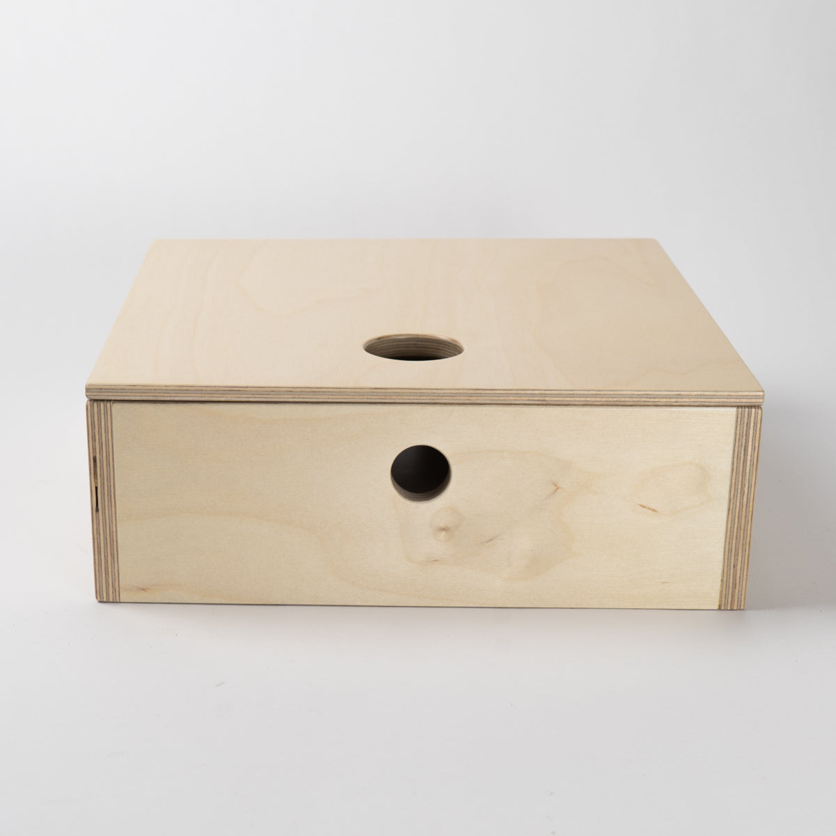 Wooden box with circular holes on a white background