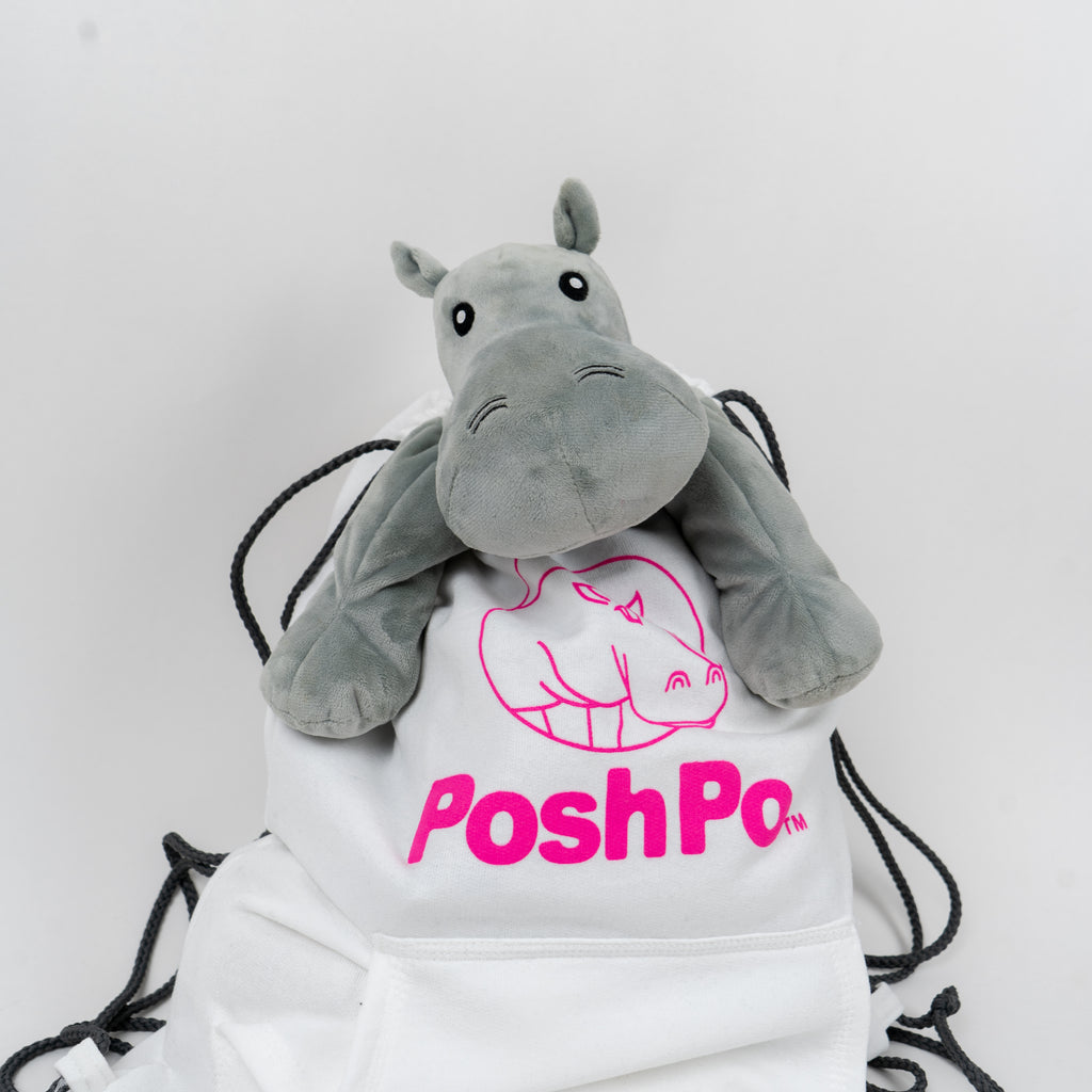 White bag with pink 'PoshPo' logo and plush hippo toy on a white background
