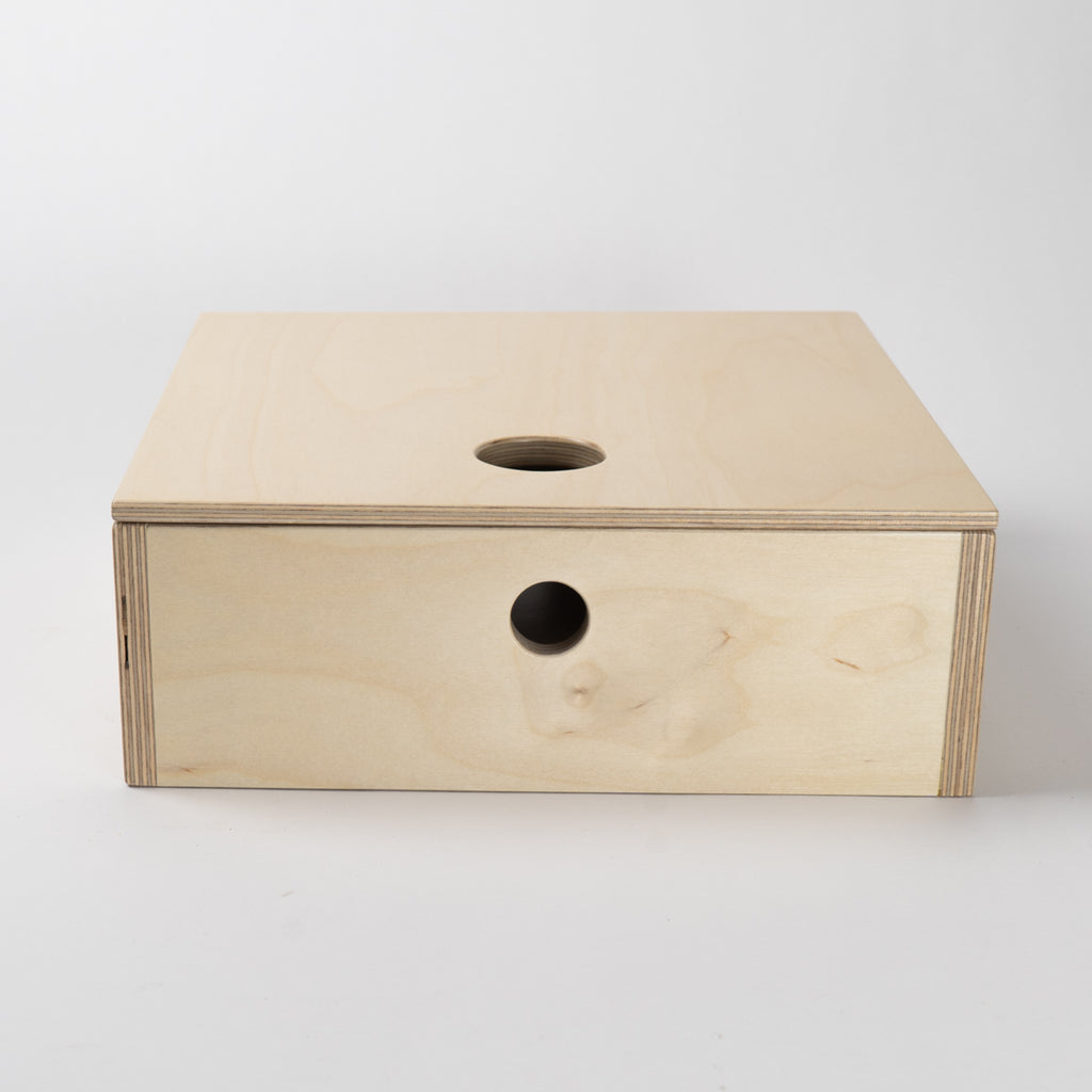 Wooden box with circular holes on a white background