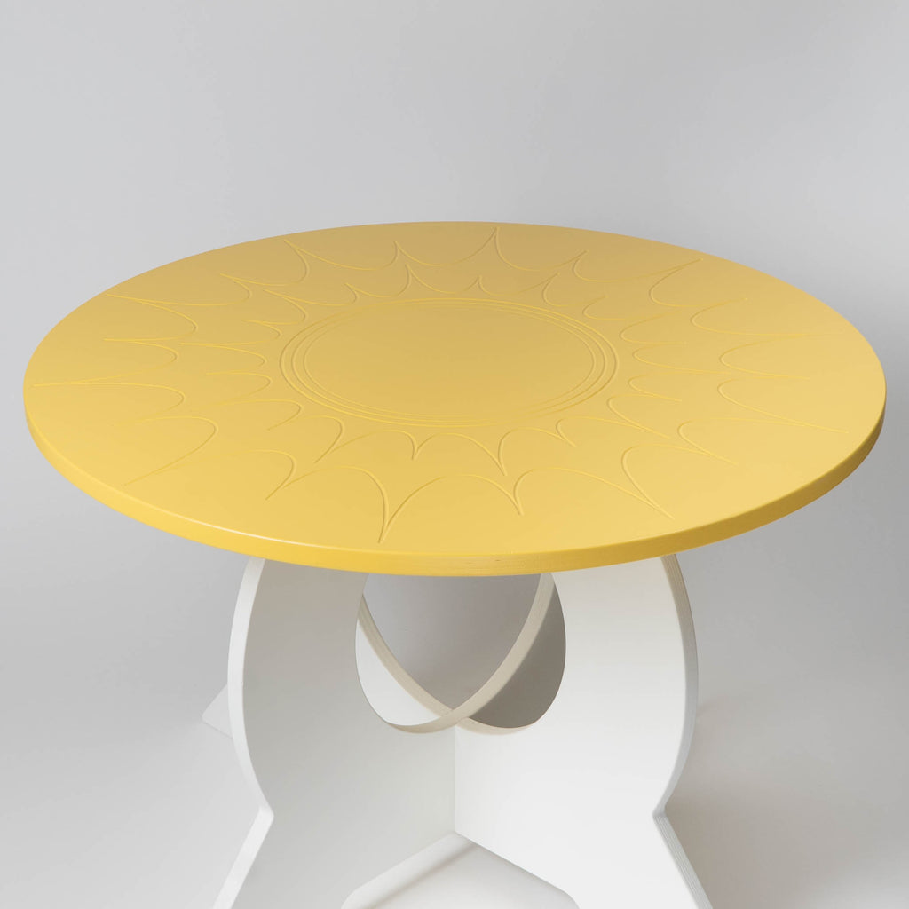 Round yellow table with white base on a light gray background