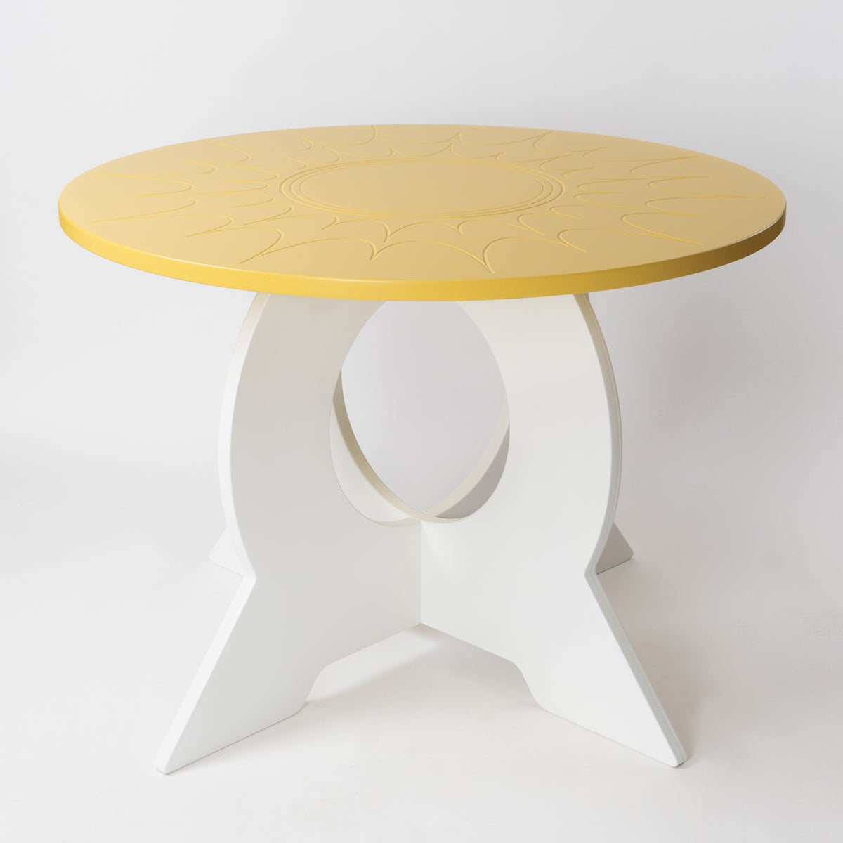 Round table with yellow top and white base on a light gray background
